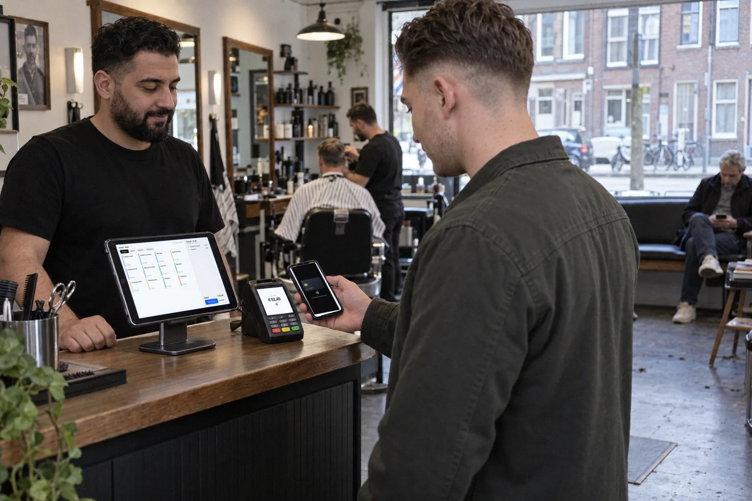 A customer pays at the desk of a barbershop
